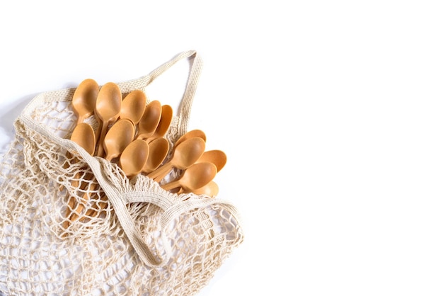 Cotton net shopper with many spoons on white background