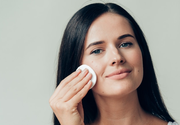 Cotton pad woman face remove makeup healthy skin natural makeup.  Studio shot.