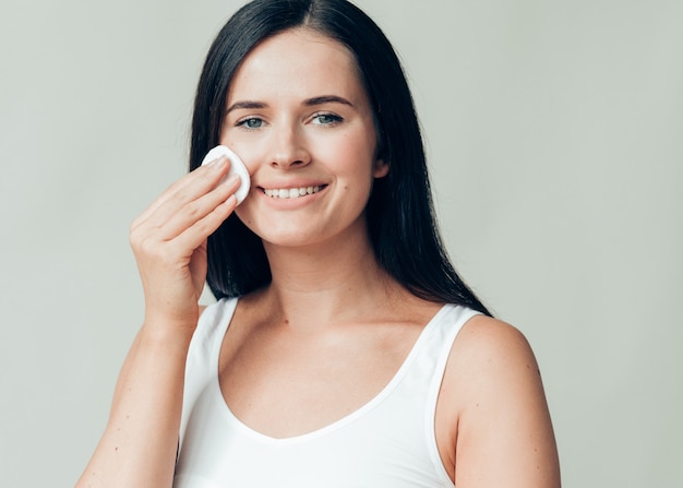 Cotton pad woman face remove makeup healthy skin natural makeup.  Studio shot.