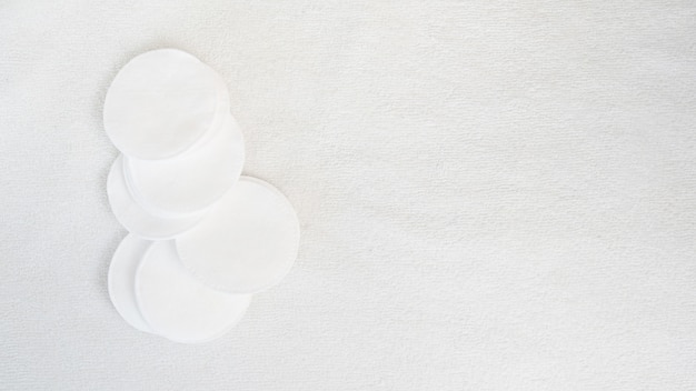 Cotton pads on white towel background