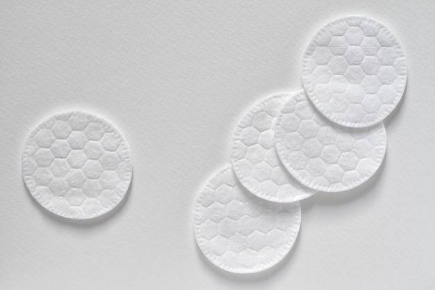 Cotton sponges or cotton cosmetic pads on the light background. Closeup, top view