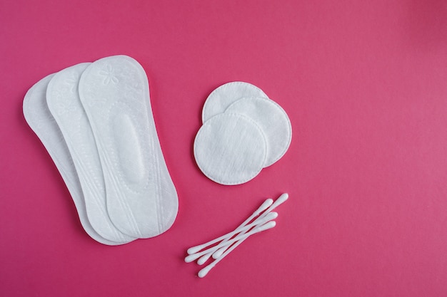 Cotton swabs and disks isolated on a pink background. Hygiene products.