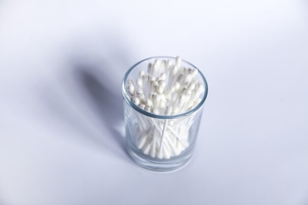 Cotton swabs or ear sticks in glass storage.