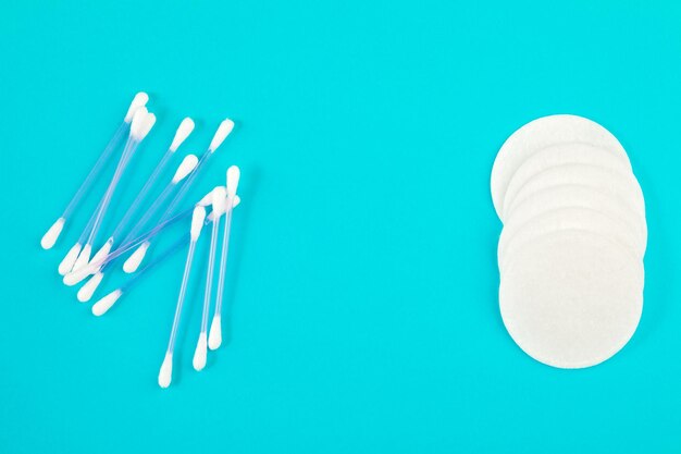 Photo cotton swabs and pads on a blue background. hygiene products.