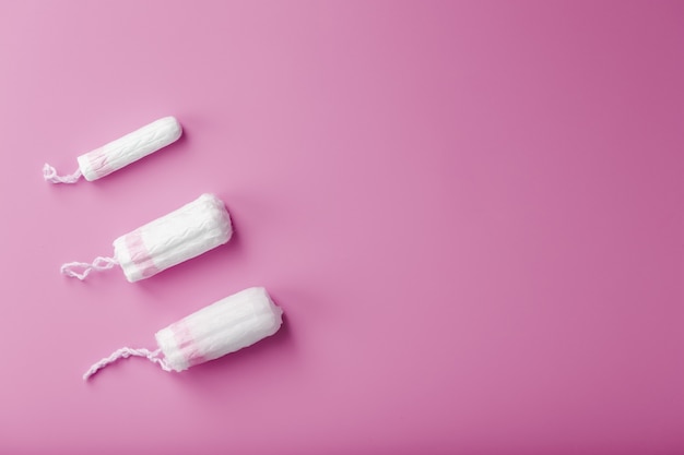 cotton tampons on a pink background with a free space