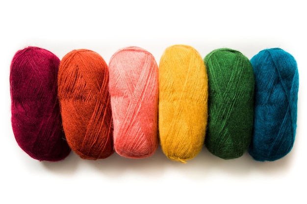 白い背景に分離された明るい色の綿糸編み物用の糸は水平に並んでいます
