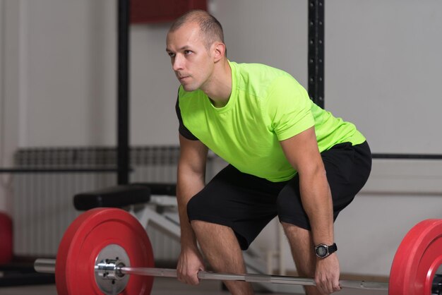 Couch Doing Heavy Weight Exercise For Back With Barbell In Gym