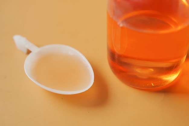 Cough medicine bottle with poured dose on counter