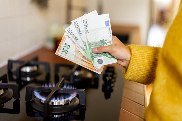 Counting euro banknotes near burning gas stove