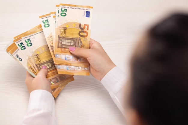 Подсчет евро крупным планом женских рук считает пачку банкнот евро успешным бизнесом
