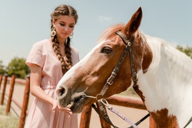 Ragazza del paese che alimenta un cavallo in un ranch