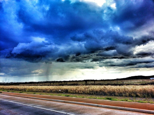 Country road against cloudy sky