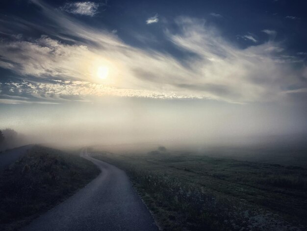 Foto strada di campagna lungo il paesaggio contro il cielo