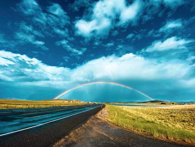 Country road amidst landscape against sky