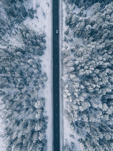 Country road going through the beautiful snow covered landscapes Aerial view Drone photography