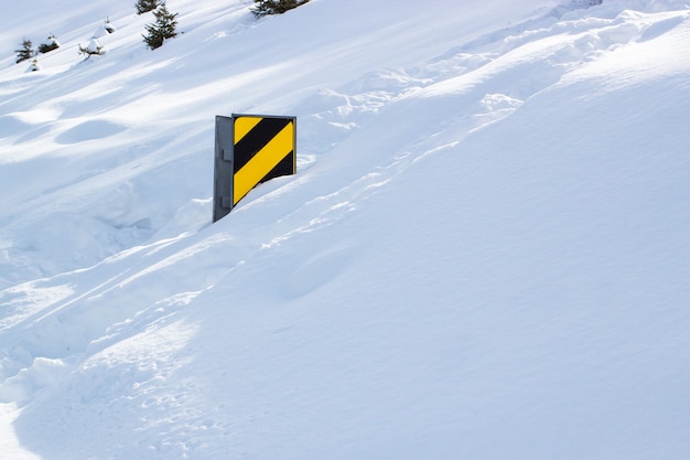 晴れた日の大雪の後の田舎道標識。