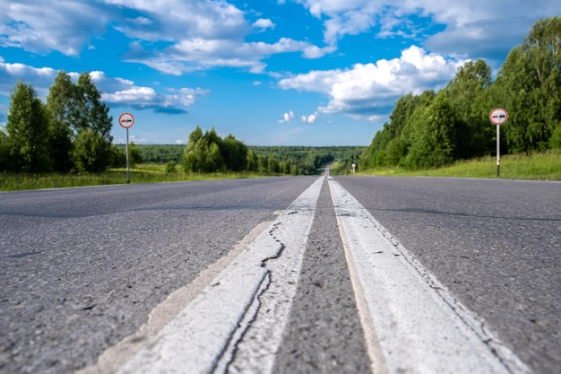 Country road with markings in the middle of the forest