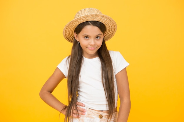 Country style small beauty happy kid on yellow background she love summer vacation spring fashion for kids childhood happiness cheerful little girl wear straw hat ready for beach party