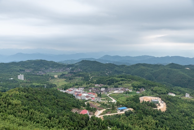 A country surrounded by forests on a cloudy day