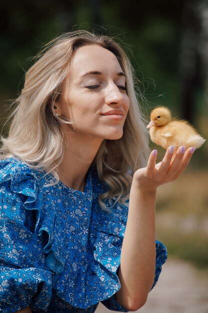 Photo country woman holding a duckling in her arms