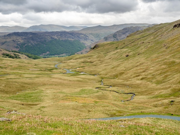 イギリスの曇り空の下で緑の野原と山の背景の田園風景ビュー