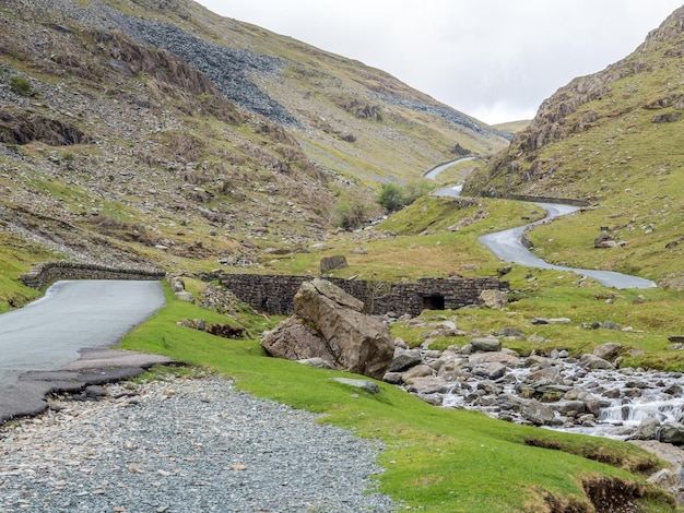 イギリスの曇り空の下で緑の野原と山の背景の田園風景ビュー