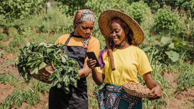 Donne di campagna che passano in rassegna insieme un telefono