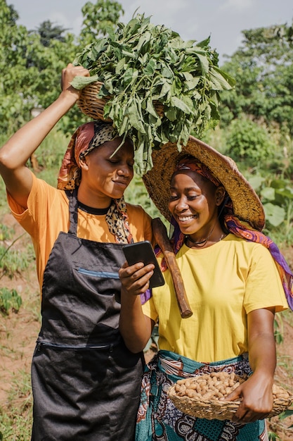 Donne di campagna che passano in rassegna insieme un telefono