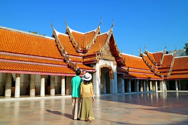 タイのバンコクにあるワットベンチャマボピット大理石寺院の素晴らしい回廊を賞賛するカップル