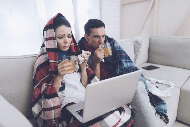 Couple are drinking therapeutic tea from glass cups.