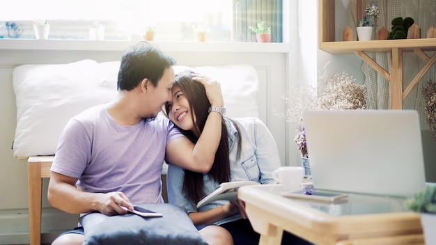 Couple of Asian Lover sitting together and reading book in the morning with warm feeling