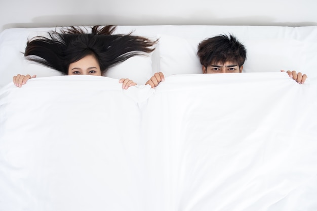 Photo couple asian man and woman on bed in white bedroom