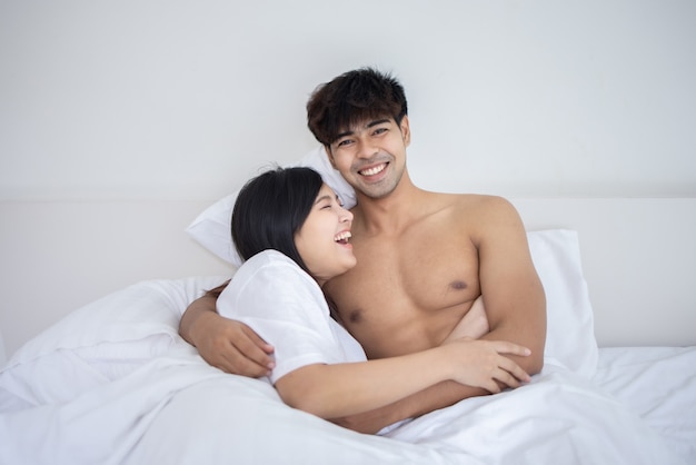 Photo couple asian man and woman on bed in white bedroom