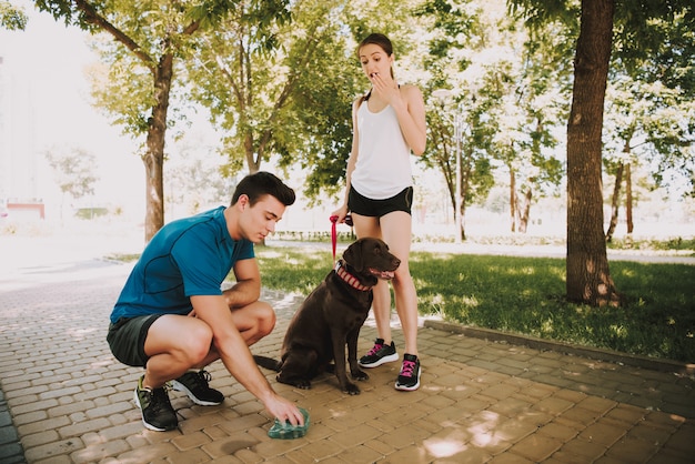 緑豊かな公園で彼らの犬と一緒に運動選手のカップル
