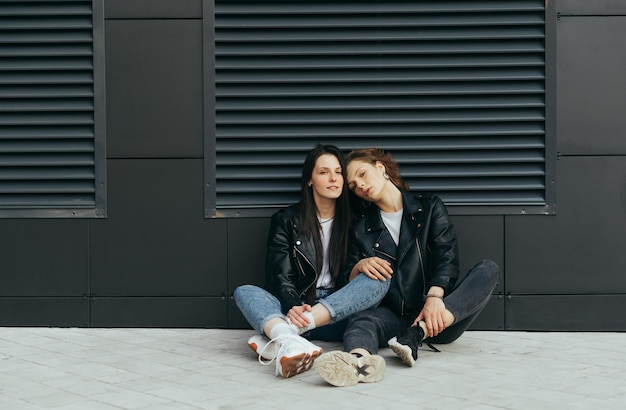 Coppia di ragazze attraenti in abiti casual eleganti che indossano giacche di pelle