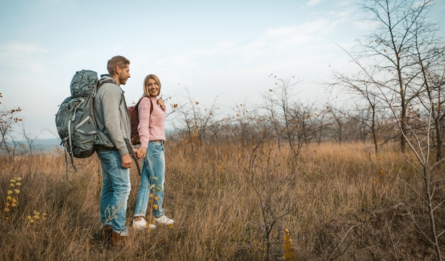 Couple Of Backpackers Travels Holding Hands In Nature