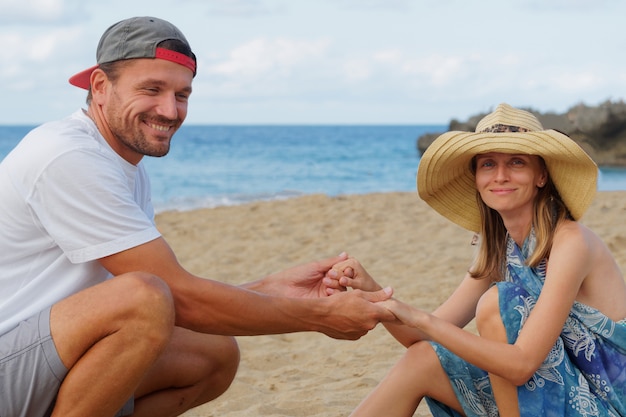 Couple on beach laughing having fun lifestyle.
