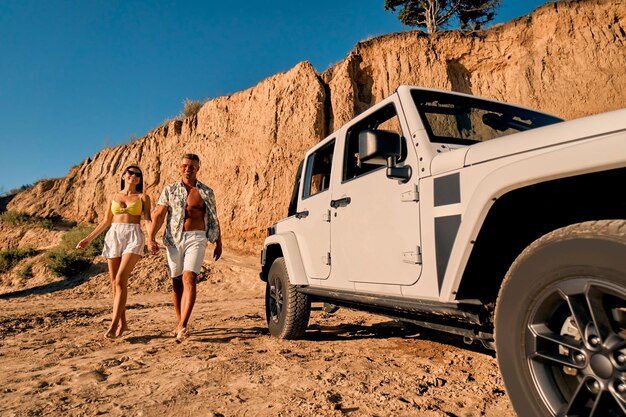 Couple on beach with car