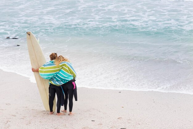 Couple on the beach with surfboard