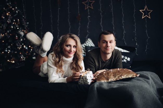 Couple on bed with Christmas present  New Year