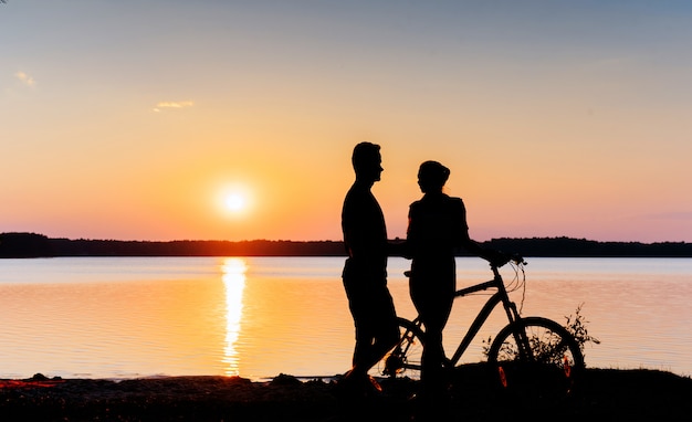 湖で日没で自転車をカップルします。