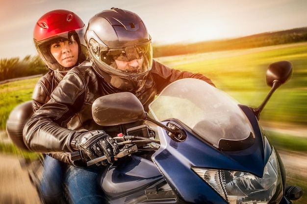 Couple Bikers in a leather jacket riding a motorcycle on the road