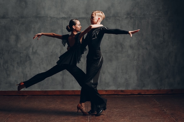 Couple in black dress dancing ballroom dance rumba.