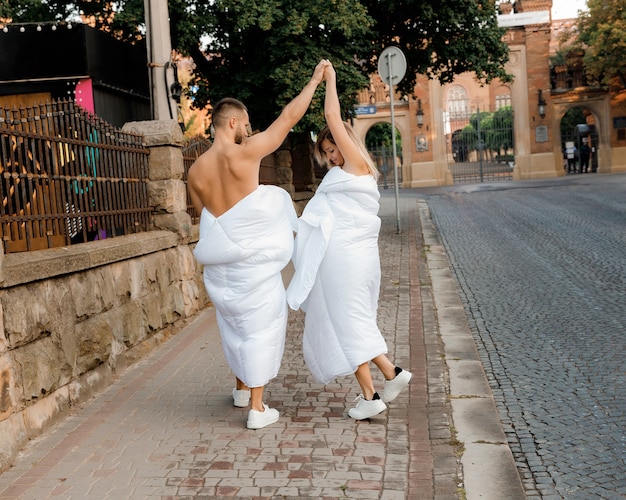 A couple in blankets walking around the city