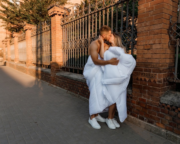 Foto una coppia con le coperte in giro per la città