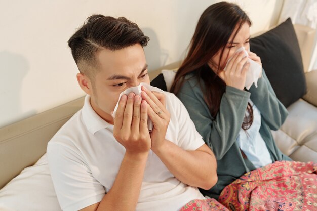 Couple blowing noses