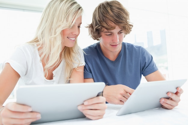 A couple both using tablets