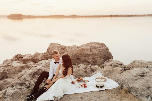 couple of bride and groom at romantic picnic on the seashore