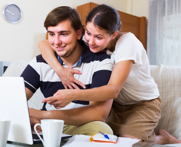 couple browsing web and making notes indoors