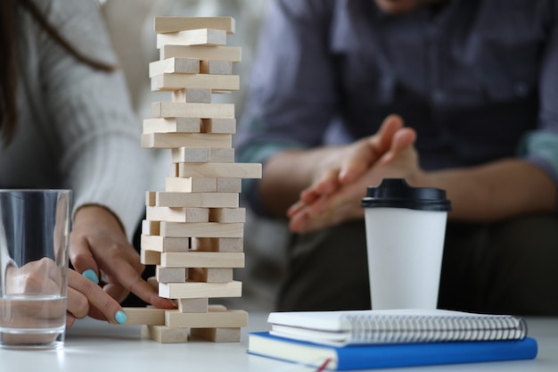 Couple build tower from wood block